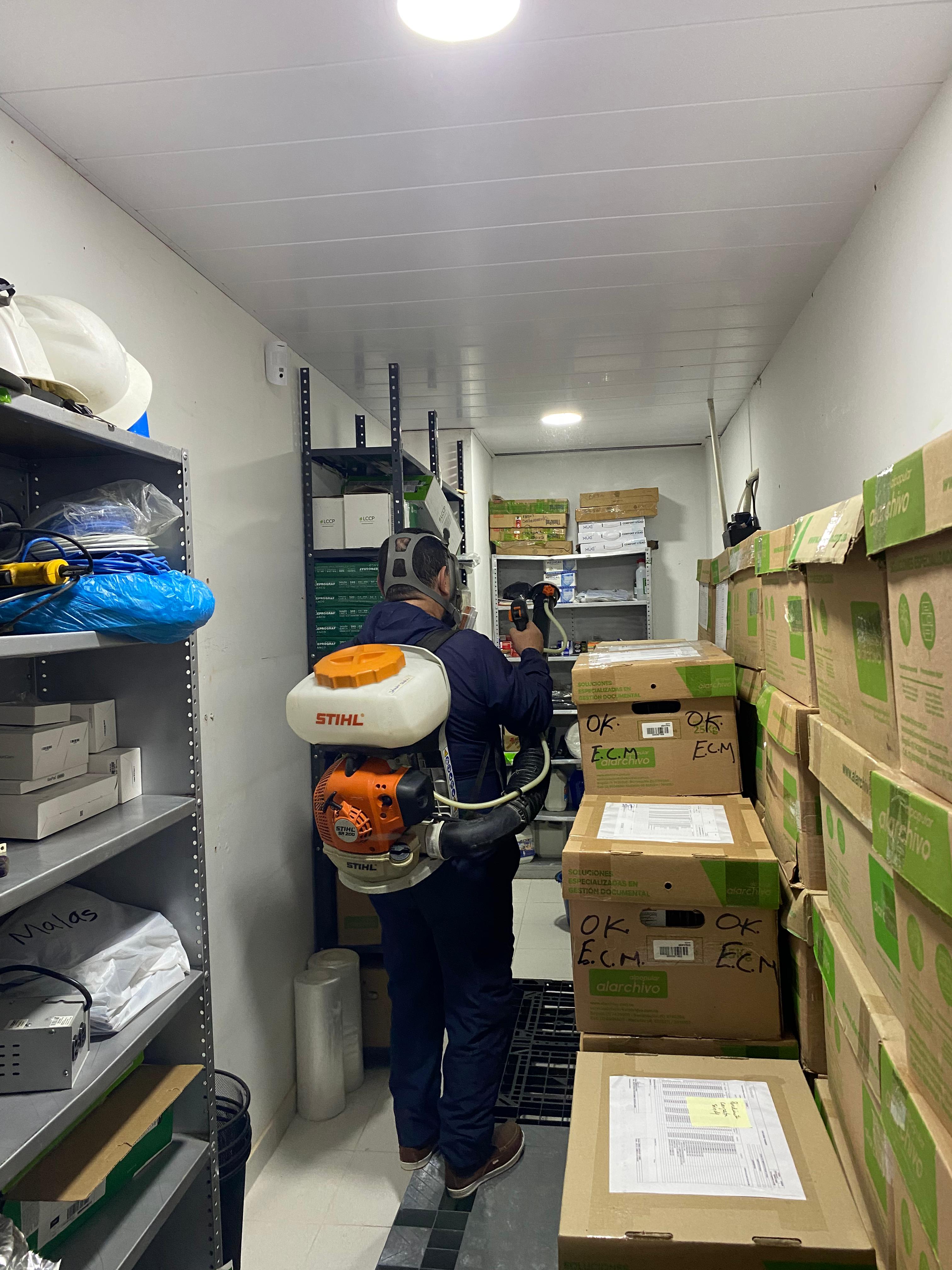Técnico fumigando interior de instalaciones